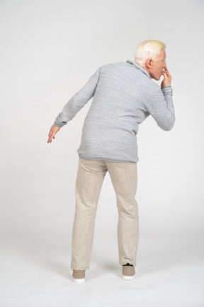 Back view of a man standing and biting nails
