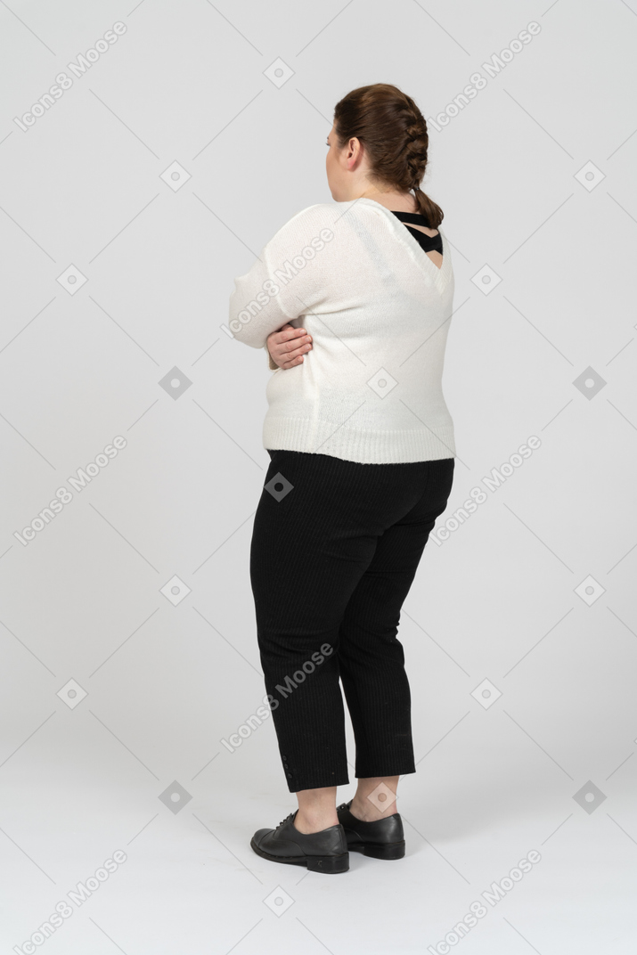 Plump woman in casual clothes posing with arms crossed