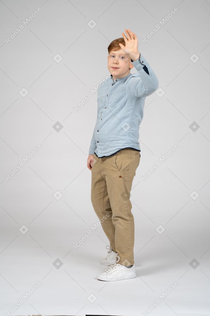 Side view of a cute boy waving