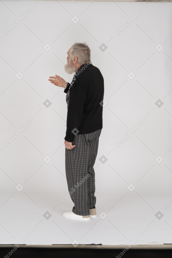 Back view of old man standing with raised arm