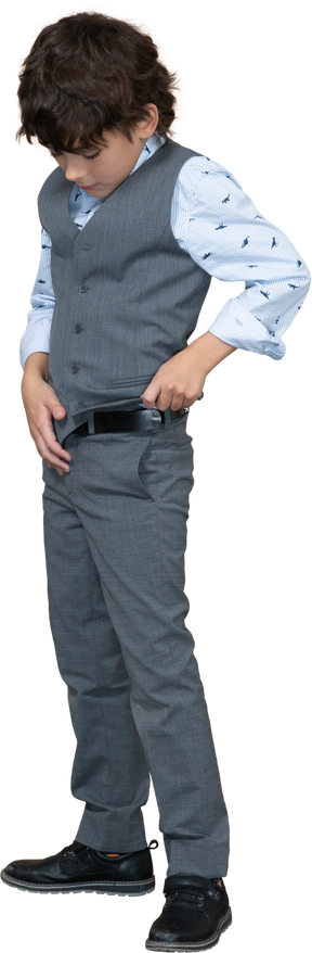 Front view of a boy in suit standing with hands on belt