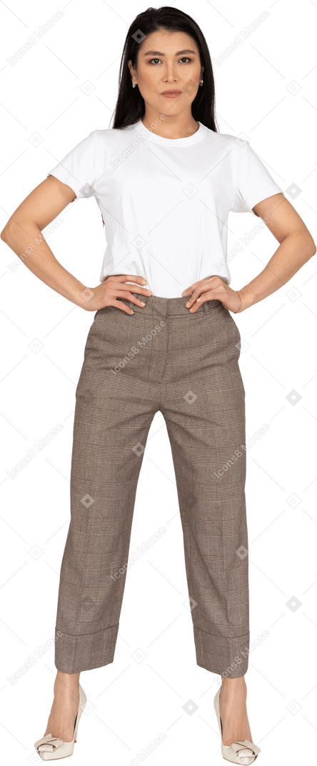 Front view of a young woman in breeches putting hands on hips