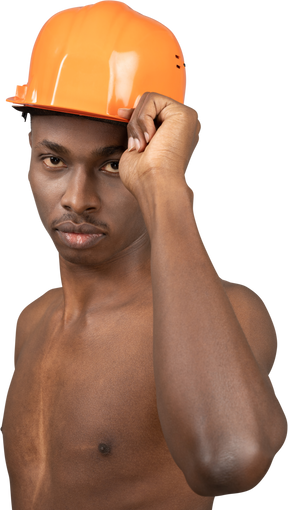 Naked young man wearing construction helmet