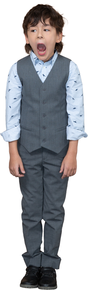 Front view of a boy in grey suit standing with open mouth