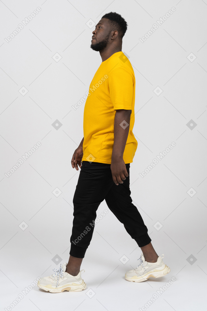 노란 티셔츠를 입은 짙은 색 피부의 젊은 남자의 옆모습