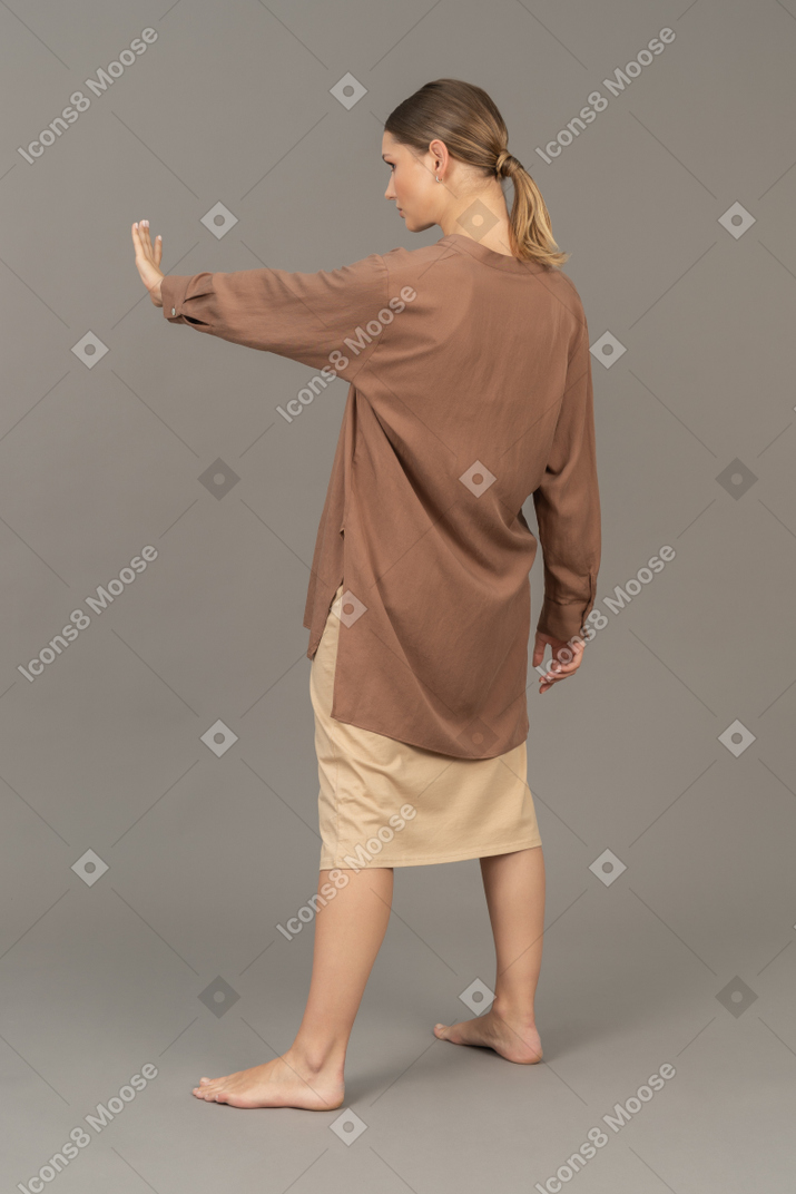まっすぐな腕を持つ若い女性の背面図