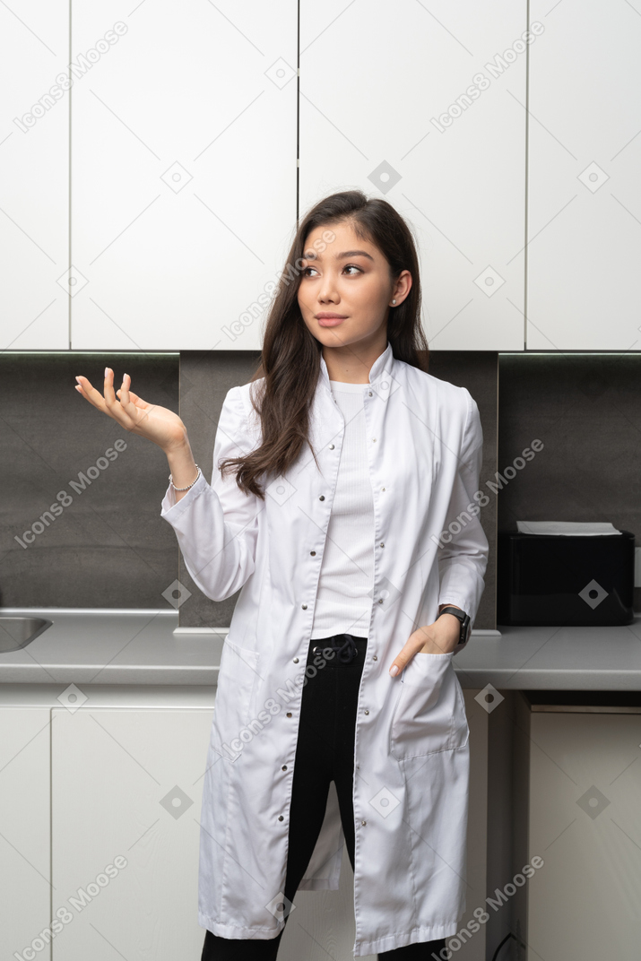 Front view of a gesticulating female doctor looking aside