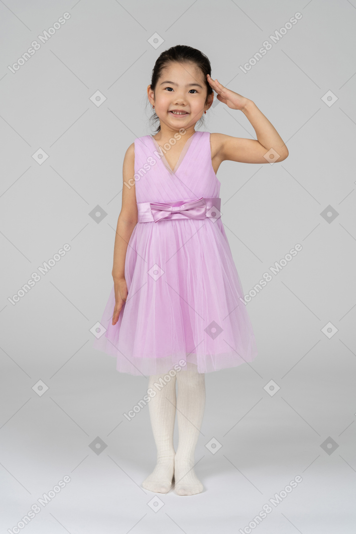 Petite fille en robe rose saluant