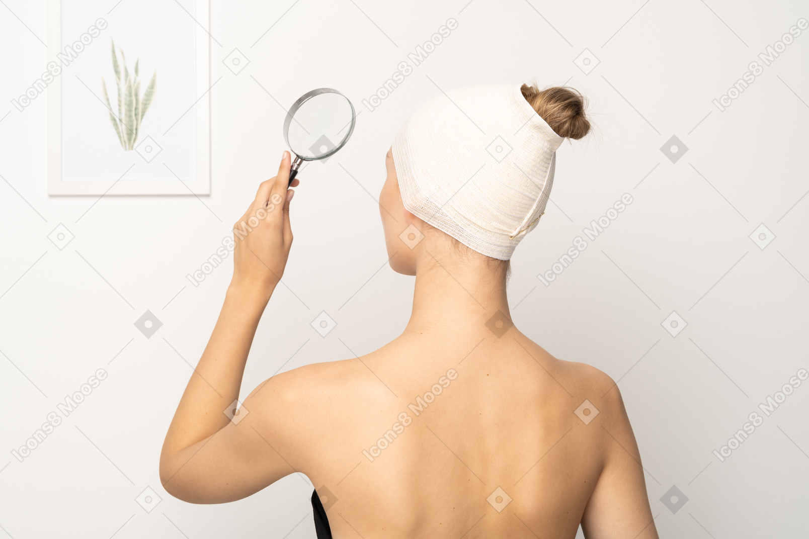 Back view of a woman holding up magnifying glass