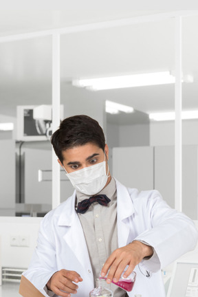 A man in a lab coat and a face mask