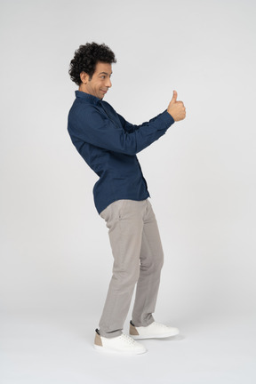 一个穿着休闲服的男人竖起大拇指的侧视图