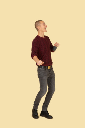 Three-quarter view of a young laughing man in red pullover