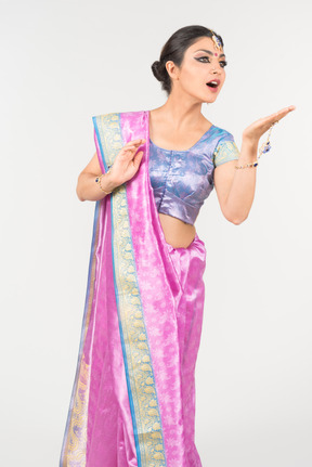 Young indian woman in purple sari standing with hands folded