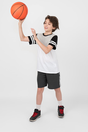 Niño moviendo y lanzando una pelota de baloncesto