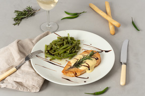 Plat de morceaux de saumon avec sauce et haricots verts