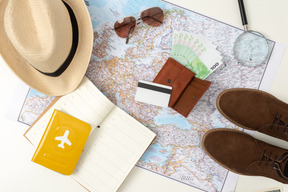 Des lunettes de soleil, un chapeau de paille, des bottes, un passeport international et une carte avec un itinéraire touristique qui traîne la seule chose qui peut tout remplacer : l'argent