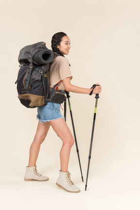 Donna escursionista in piedi con bastoncini da trekking