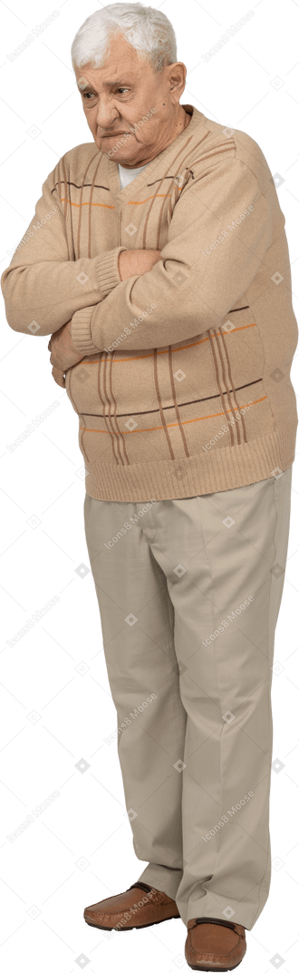 Vista frontal de um velho mal-humorado em roupas casuais em pé com os braços cruzados