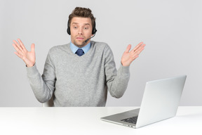 Call center agent sitting at the table and not understanding something