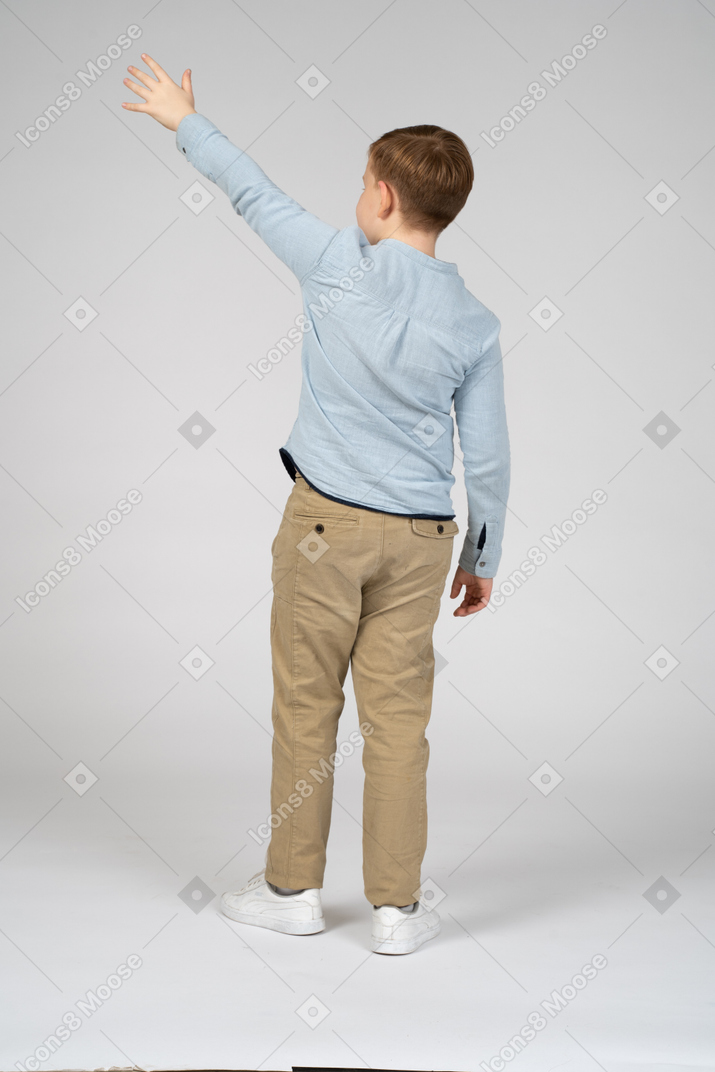 手を振っている少年の背面図