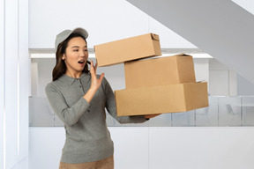 A woman holding a stack of boxes in her hands