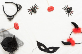 Different halloween headbands, toy spiders and a black mask