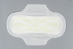 Sanitary pad with wings over gray background