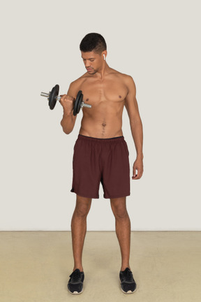 Front view of strong man working out with dumbbell