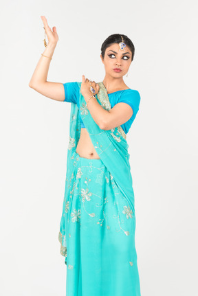 Jeune femme indienne en sari bleu debout en position de danse