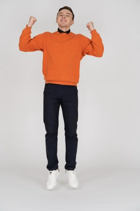 Young man in orange sweatshirt jumping