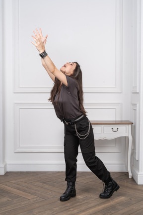Three-quarter view of a female rocker outstretching her hands