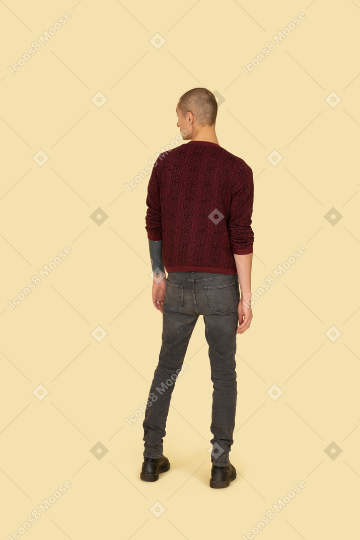 Vista traseira de um jovem com um suéter vermelho olhando para o lado