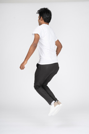 Человек в белой футболке прыгает