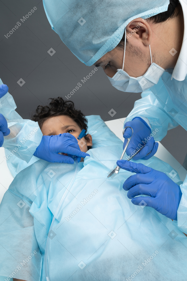 Doctor is operating on a boy