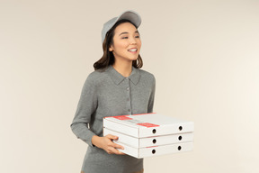 Jeune fille de livraison de pizza asiatique tenant des boîtes à pizza