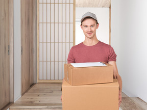 A man holding two boxes in a room