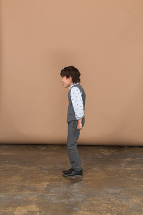 Boy in suit standing in profile