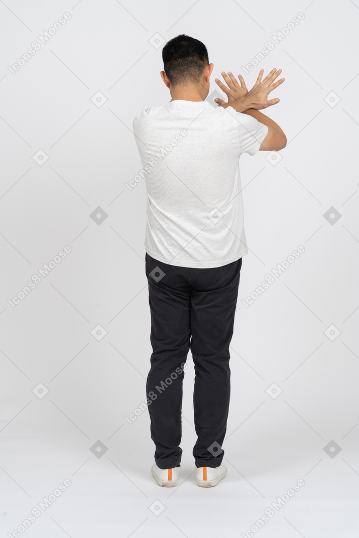 一个穿着休闲服的男人的后视图显示停止手势