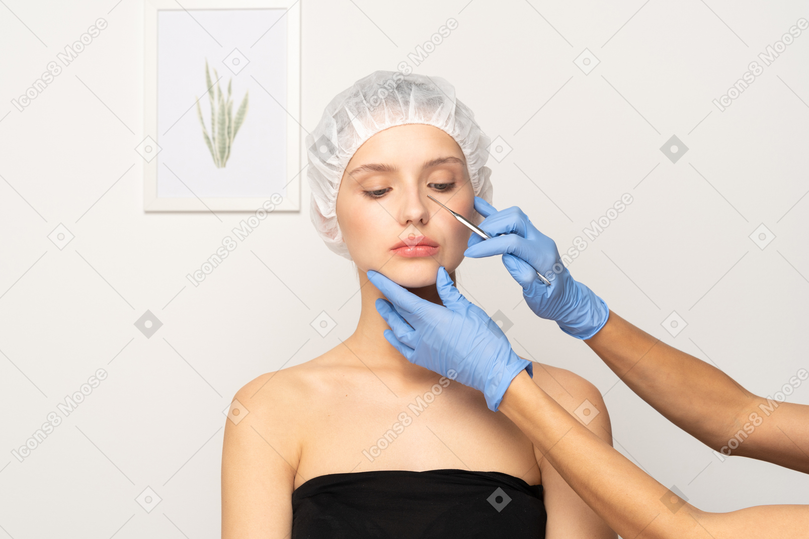 Пластический хирург держит скальпель возле лица молодой женщины