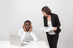 Angry female boss shouting at her upset employee