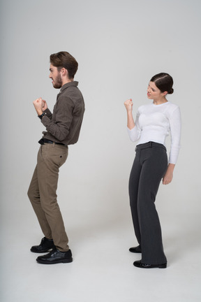 Side view of a delighted young couple in office clothing