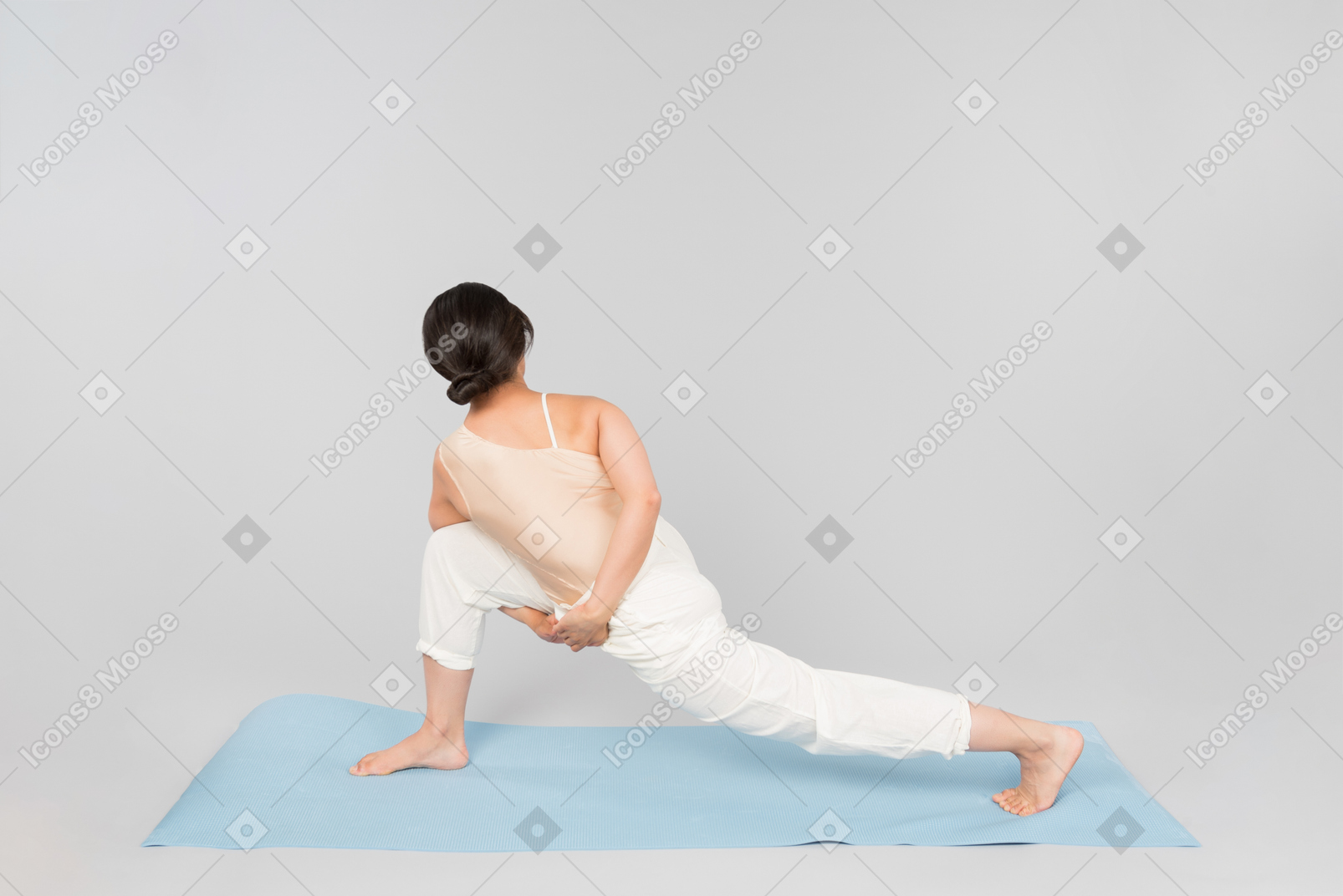 Молодая индийская женщина, стоя на коврик для йоги в позе