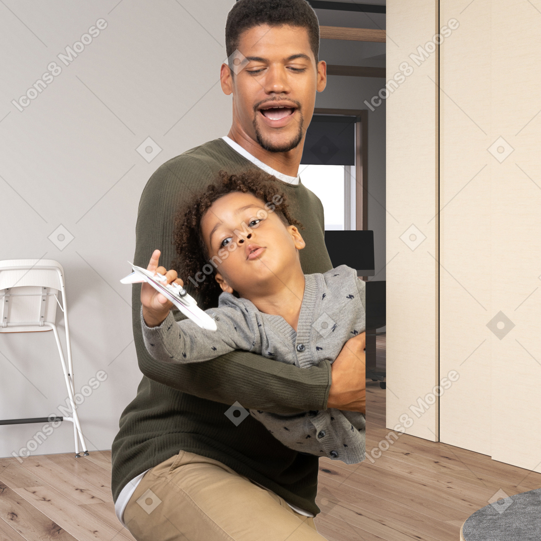 A man and a child playing with a plane
