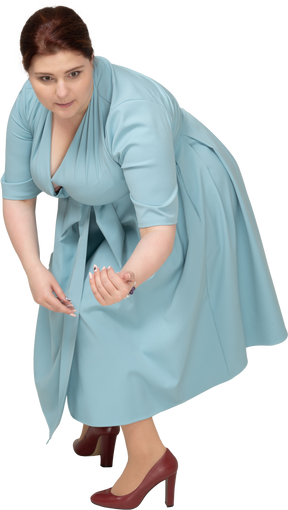 Vista frontale di una donna in abito blu accovacciata