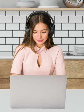A woman wearing headphones and using a laptop