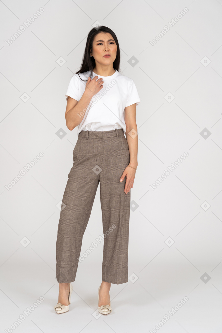 Front view of a displeased gesticulating young lady in breeches and t-shirt