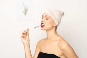 注射器を噛む若い女性の肖像画