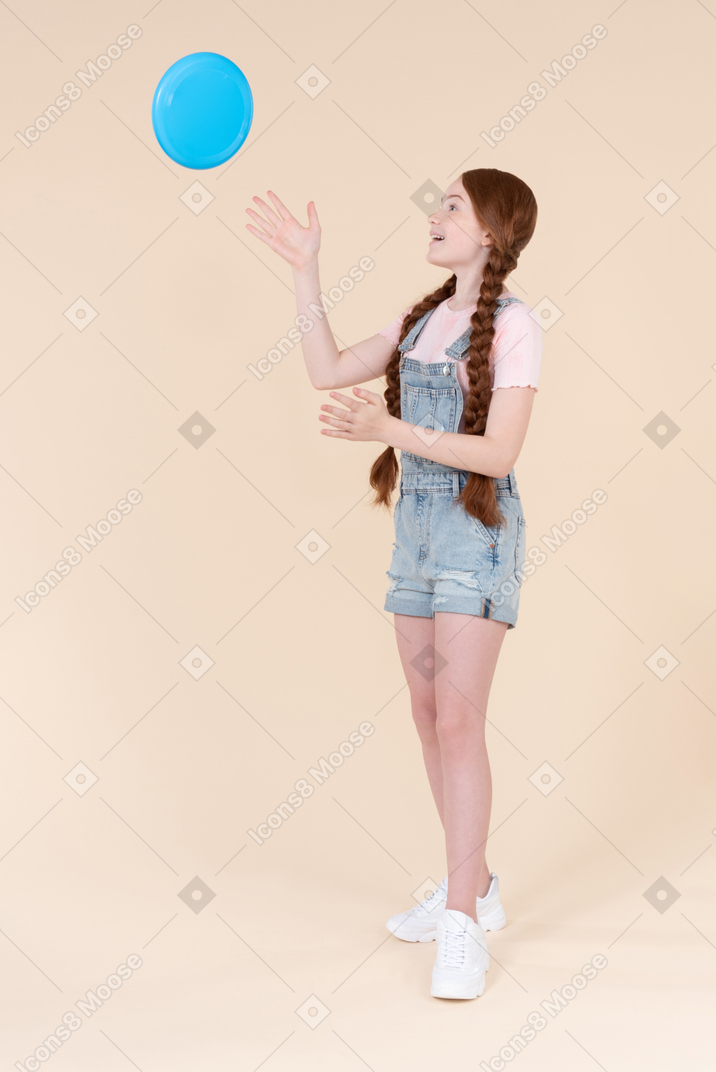 Teenage girl throwing up frisbee