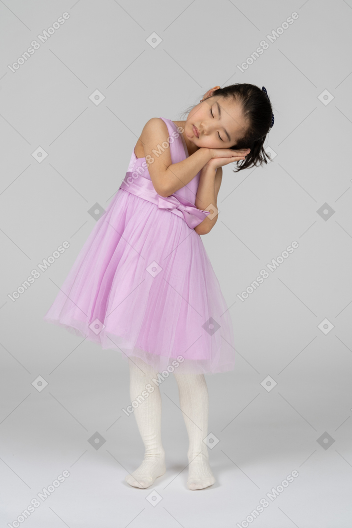 Menina com sono em pé de vestido rosa