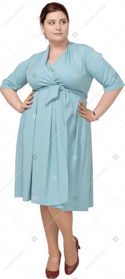 Front view of a woman in blue dress posing with hands on hips